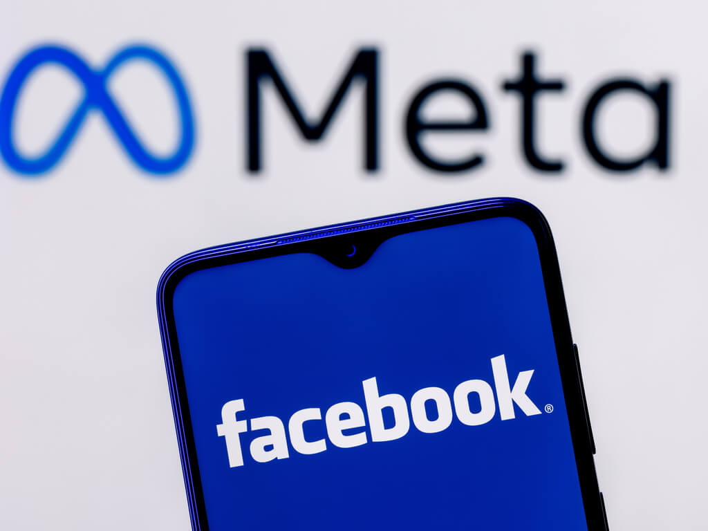 a phone with the facebook logo displayed underneath the a logo with their new name, meta
